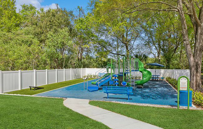 Community Playground with Slide and Corn Hole Area at Grand Pavilion Apartments in Tampa, FL.