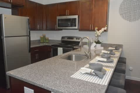 A kitchen with a granite countertop and stainless steel appliances.