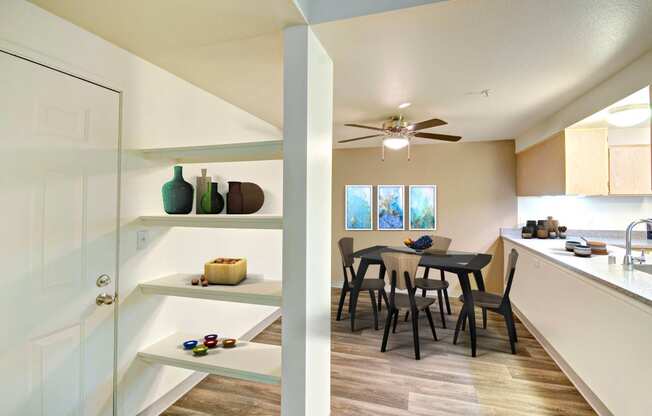 a view of a kitchen and a dining room with a ceiling fan