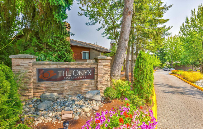 The Onyx Apartments sign is made of wood and stone.