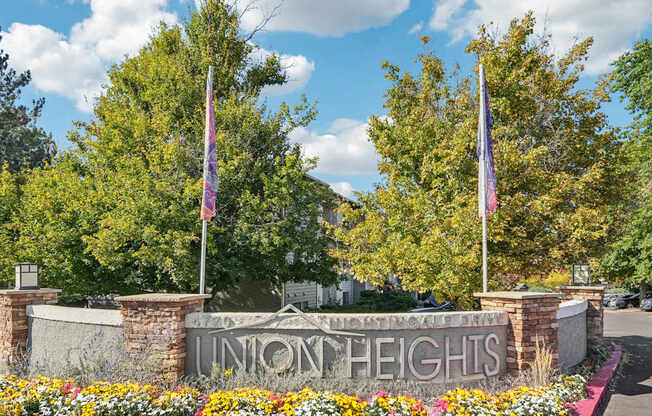 A sign that says Union Heights is in front of some trees.