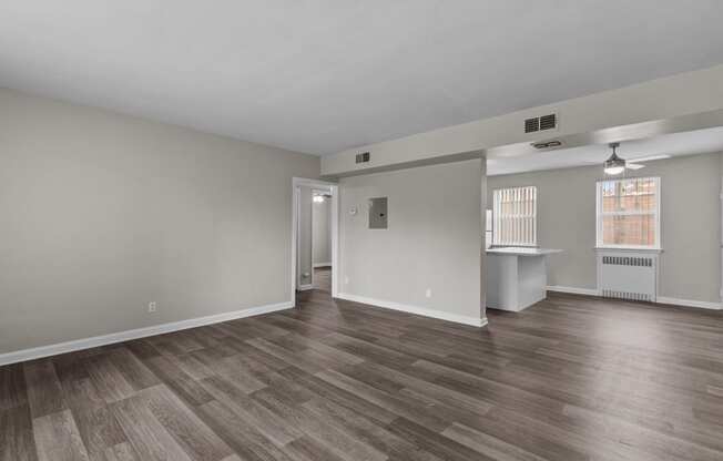the living room and dining room of an empty house with wood flooring