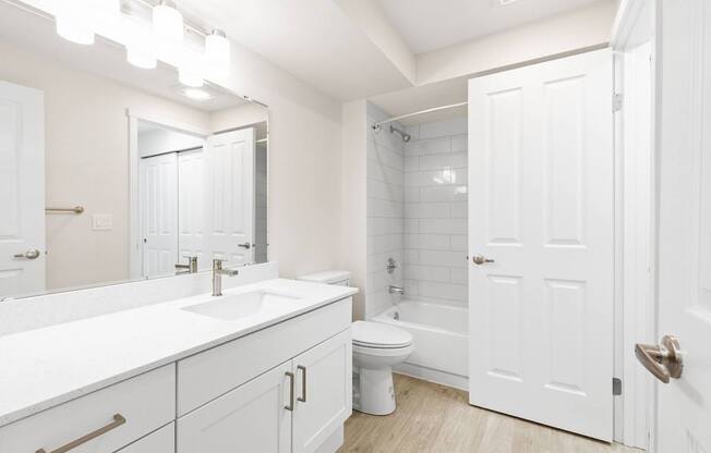 A white bathroom with a toilet, sink, and bathtub.