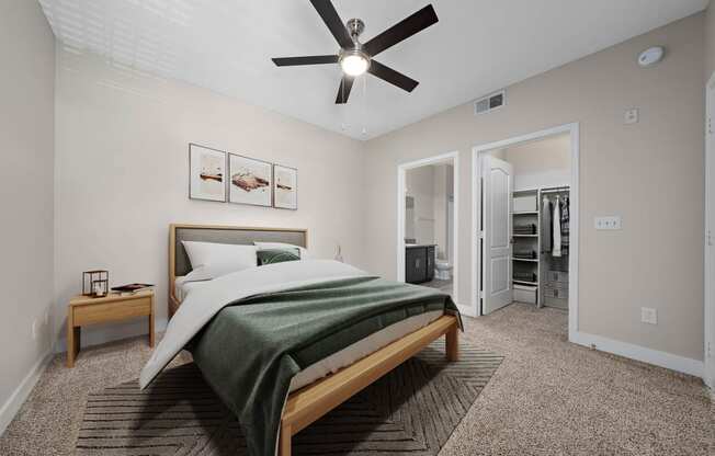 furnished bedroom with carpet floors, ceiling fan, wall art