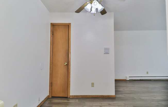 an empty room with a ceiling fan and a door