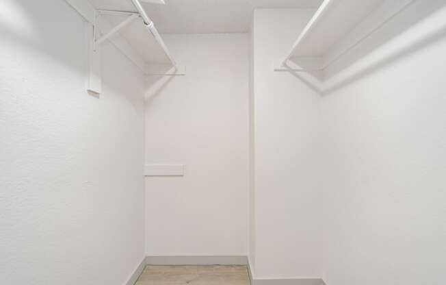 a room with white walls and two white shelves on the wall