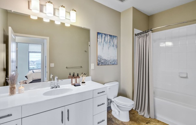 bathroom with white vanity and tub shower