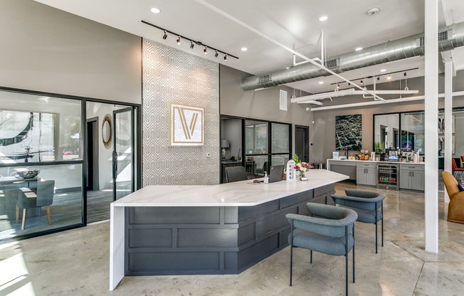 a kitchen with a large counter and chairs in a lobby