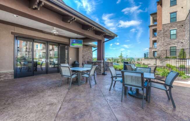 a patio with tables and chairs and a flat screen tv