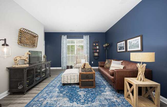 a living room with blue walls and a brown couch and a blue rug