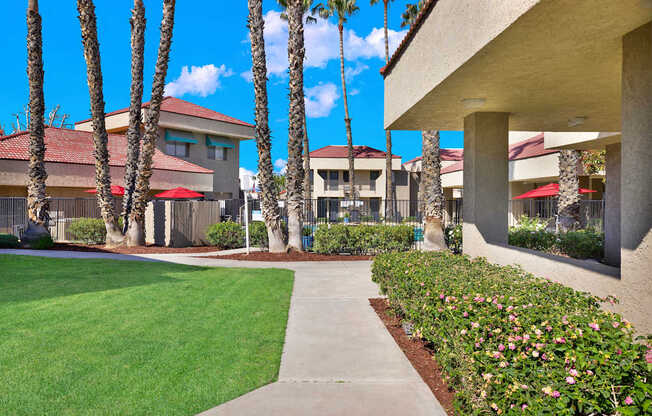 A building with a red roof and palm trees in front.