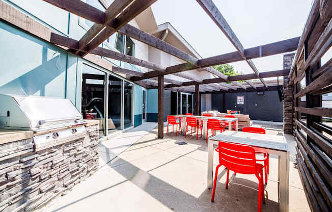 a patio with tables and chairs and a grill