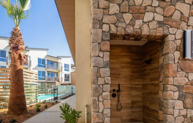 the entrance to a building with a shower and a palm tree