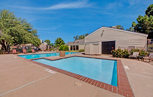 A resort-style swimming pool here at Cypress Pointe with clear blue water, wide pool decking, and surrounding lounge chairs for relaxing outdoors. A well-maintained pool area with nearby clubhouse buildings creates a comfortable and inviting community setting.