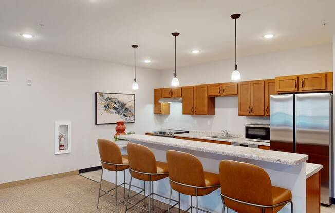 a kitchen with a bar and chairs and a refrigerator