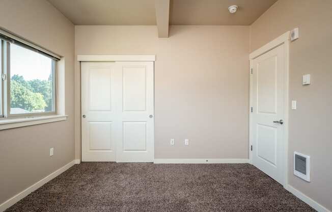 a bedroom with two doors and a carpeted floor