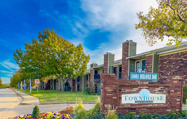 a brick building with a sign for townhouse apartments