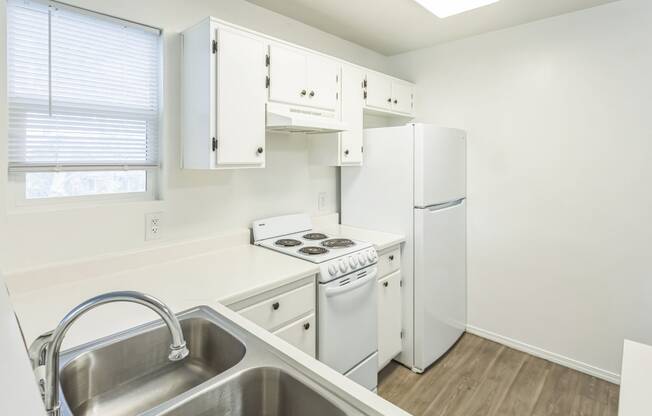 a kitchen with white appliances and white cabinets