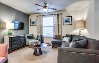 a living room with a couch and chair and a ceiling fan