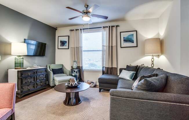 a living room with a couch and chair and a ceiling fan