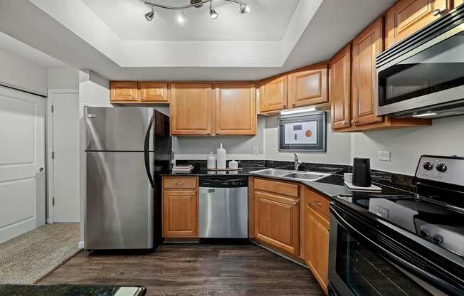 A modern kitchen with wooden cabinets and stainless steel appliances.