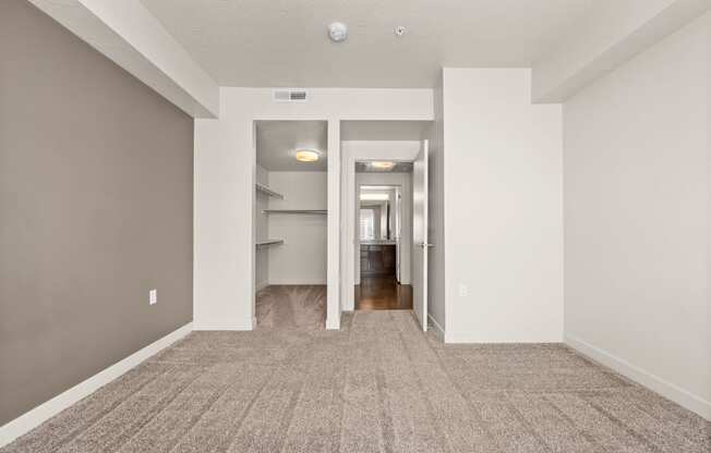 a spacious living room with gray walls and a carpeted floor