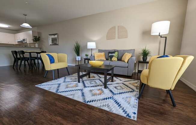a living room with yellow chairs and a rug