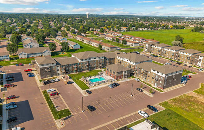 A large parking lot is surrounded by apartment buildings.