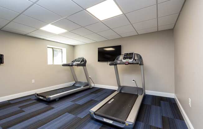 Quincy Commons gym with treadmills and a tv