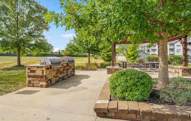 A park with a stone wall and a tree.