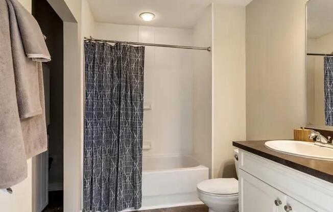 A bathroom with a toilet, sink, and shower.