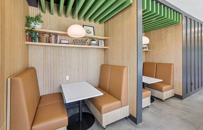 A modern dining area with tan leather chairs and a wooden table at Link Apartments® CYKEL Apartments, Charlotte, North Carolina