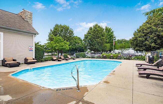 A pool with a diving board and a sign that says