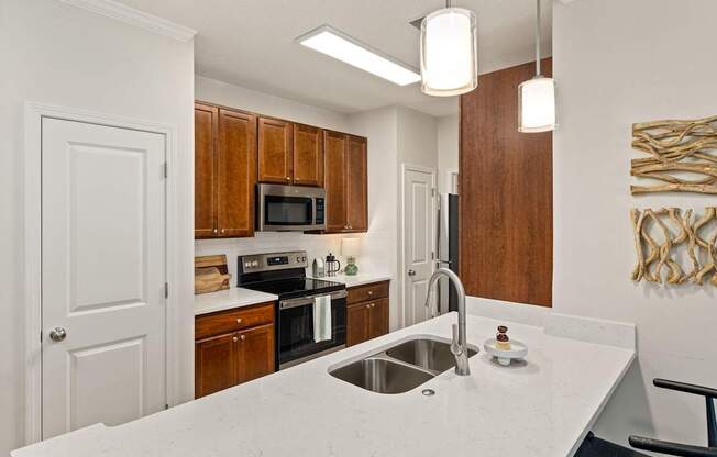 A kitchen with a white counter top and wooden cabinets.
