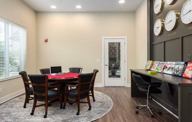 A conference room with a table and chairs and a wall of clocks.