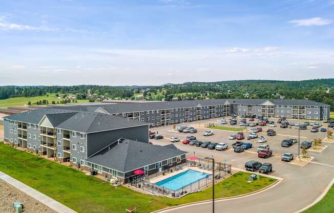 a large apartment complex with a swimming pool and parking lot