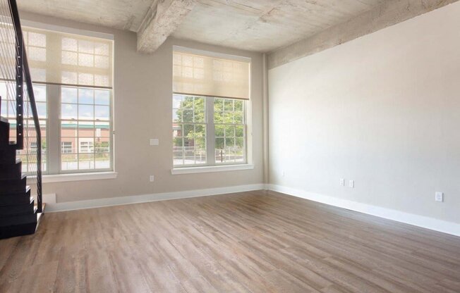 an empty living room with white walls and wood floors