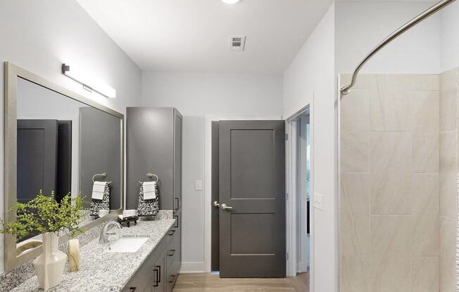 a bathroom with a shower and a sink and a mirror