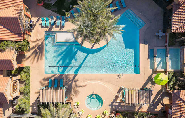 an aerial view of a swimming pool with palm trees