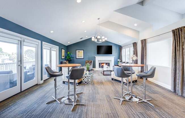 a living room with tables and chairs and a fireplace