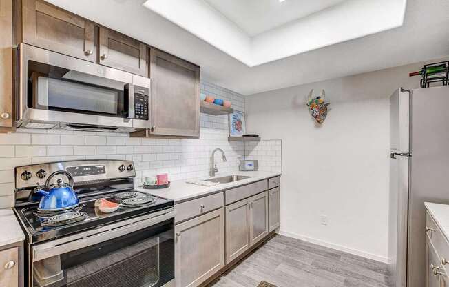 A kitchen with a stove, microwave, and refrigerator.