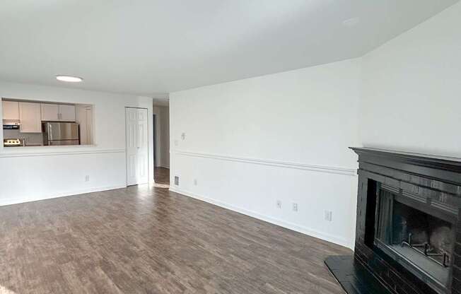 A room with a fireplace and wood flooring.