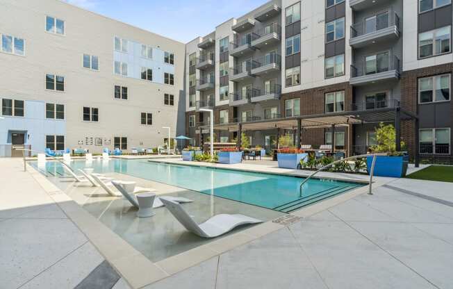 an apartment swimming pool in front of an apartment building