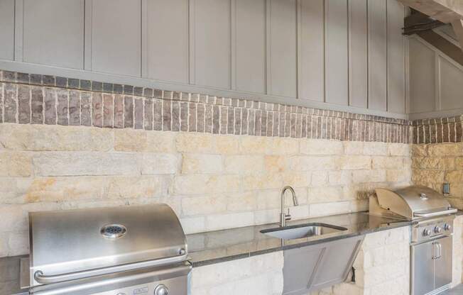 A BBQ grill is on the left and a sink is on the right.