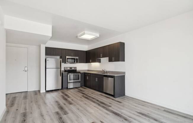 spacious apartment with custom cabinets and stainless steel appliances in the kitchen at One Santa Fe apartments