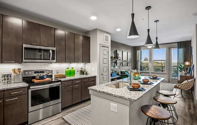 A modern kitchen with dark wood cabinets and stainless steel appliances.