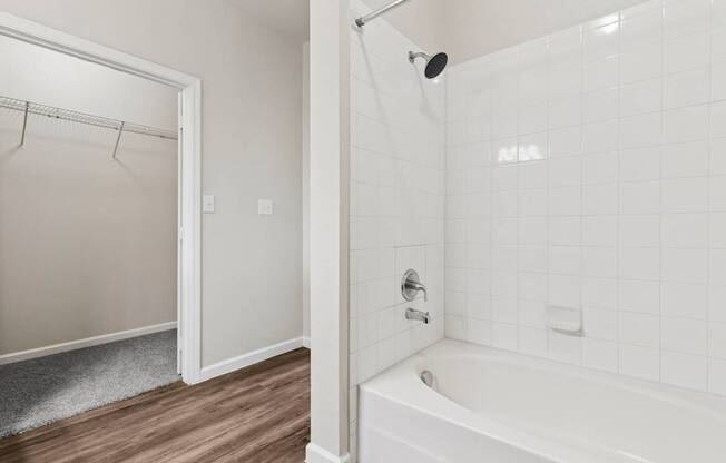 A white bathroom with a white tub and a white shower.