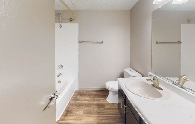 A bathroom with a white sink, toilet, and a white door.