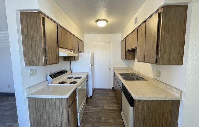 A kitchen with wooden cabinets and a white stove top oven.