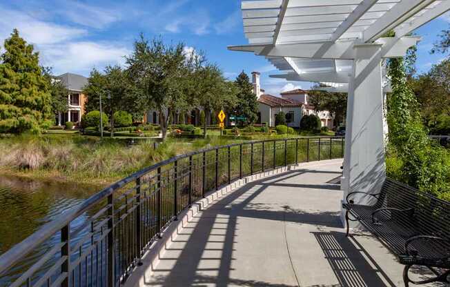 A walkway with a metal railing runs alongside a body of water.